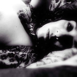 Photo d'une femme allongée avec un sein apparent