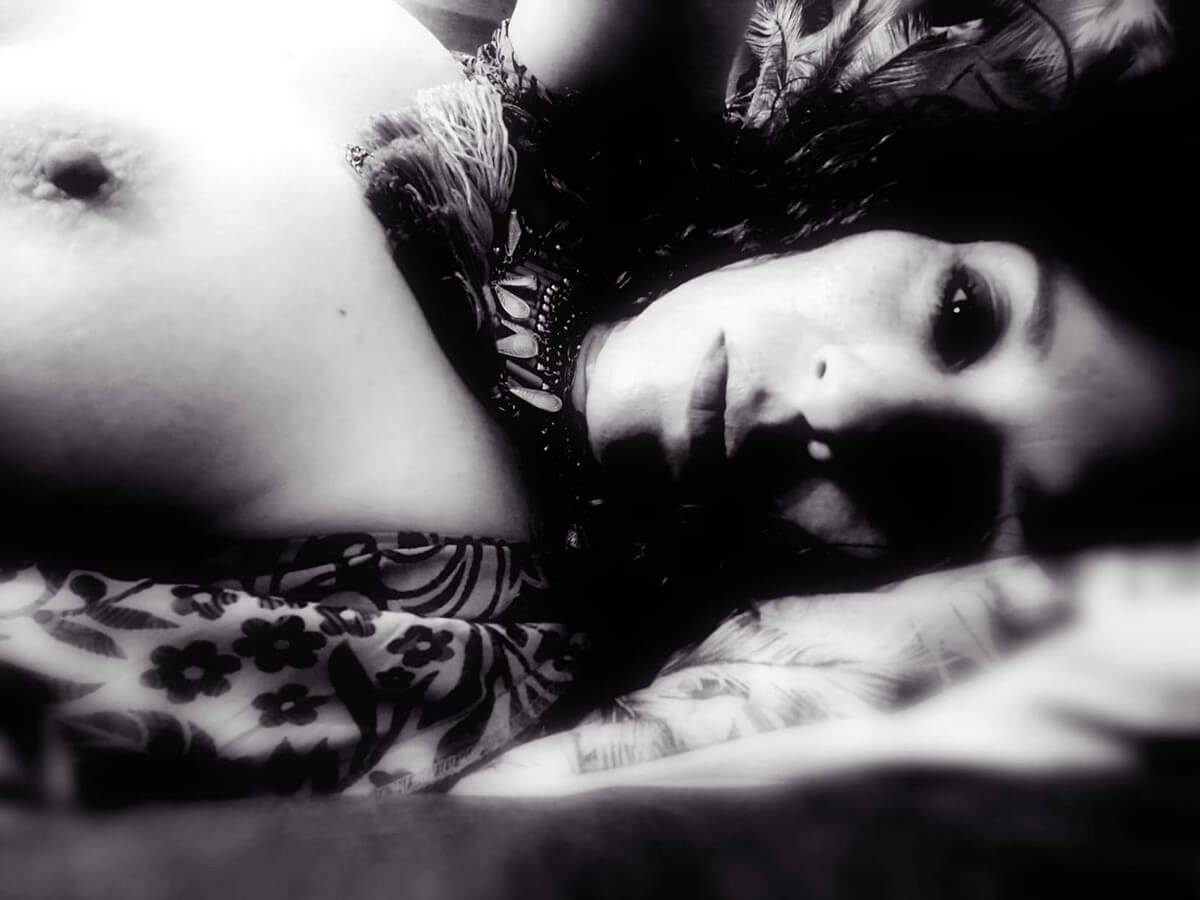 Photo d'une femme allongée avec un sein apparent