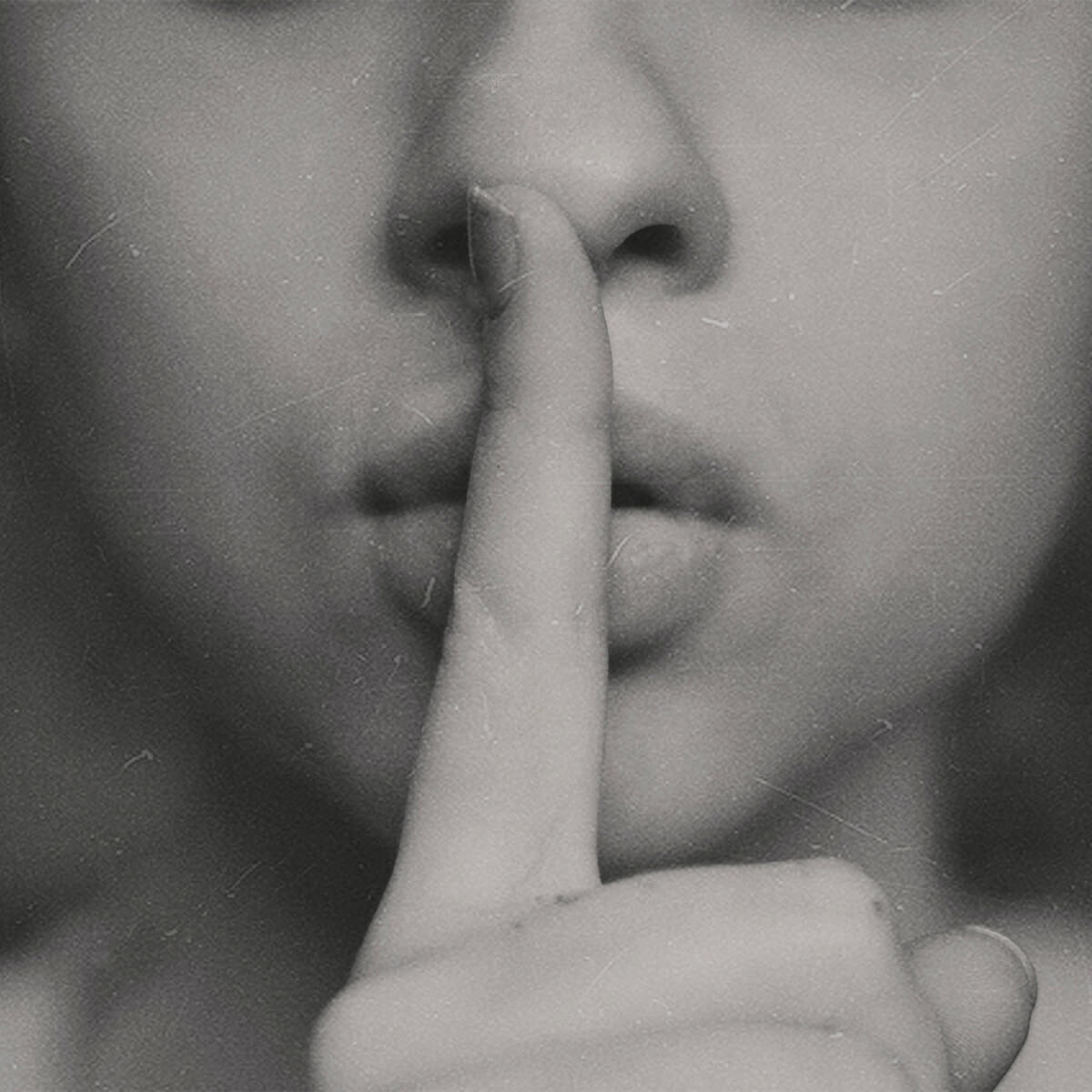 Photo en noir et blanc d'une femme avec le doigt devant la bouche